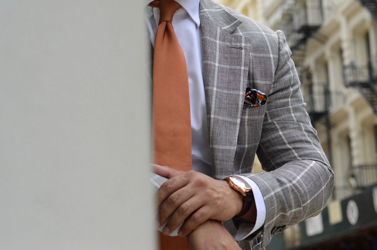 Grey windowpane jacket with an orange tie, cuff detail