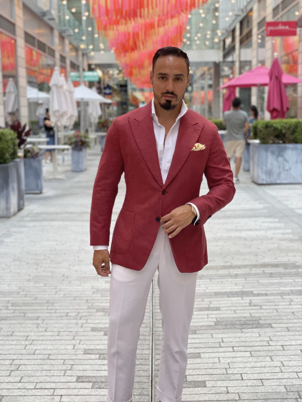 Red jacket with white trousers on a city promenade